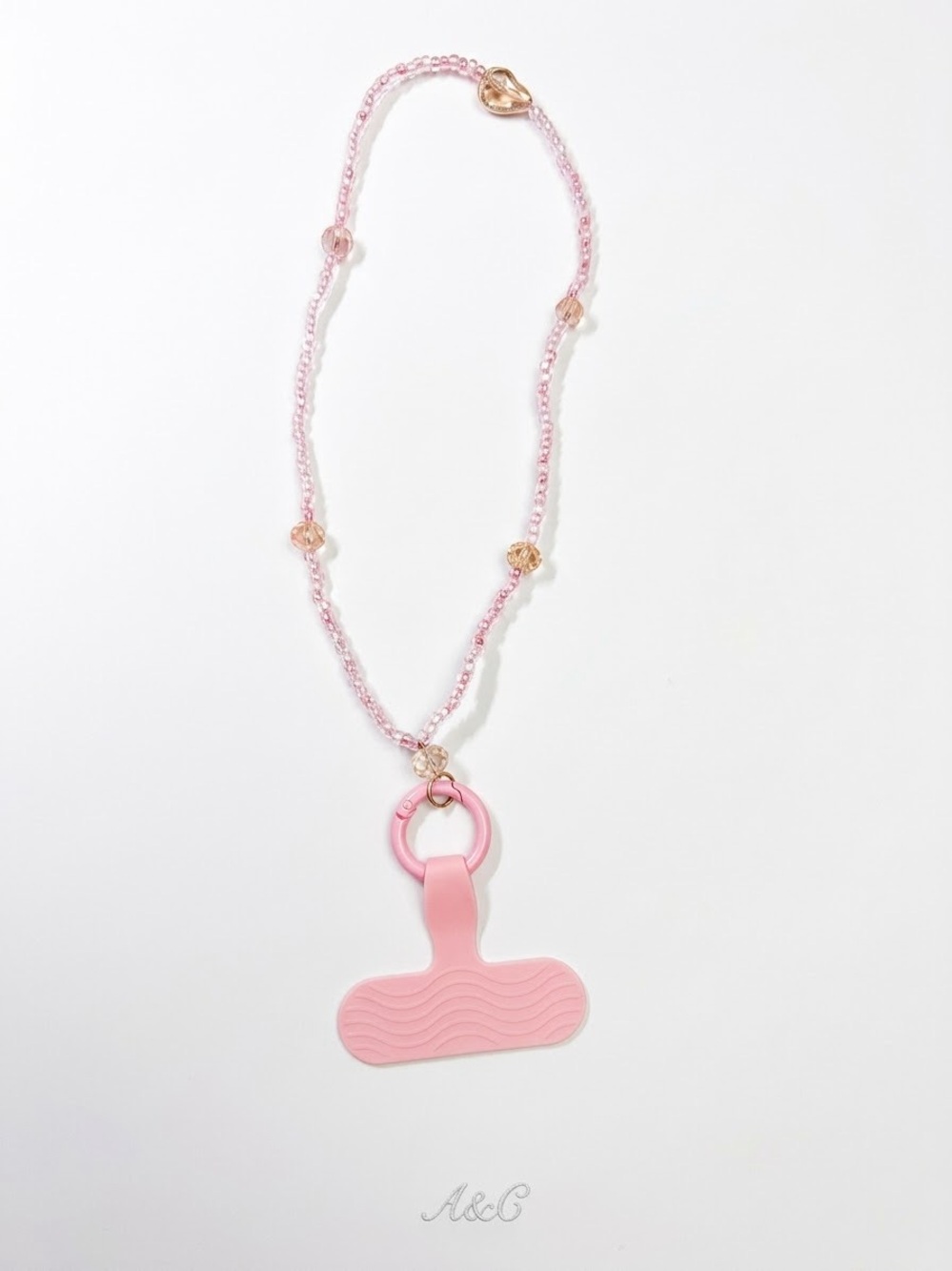 Pink glass bead phone charm accessory.